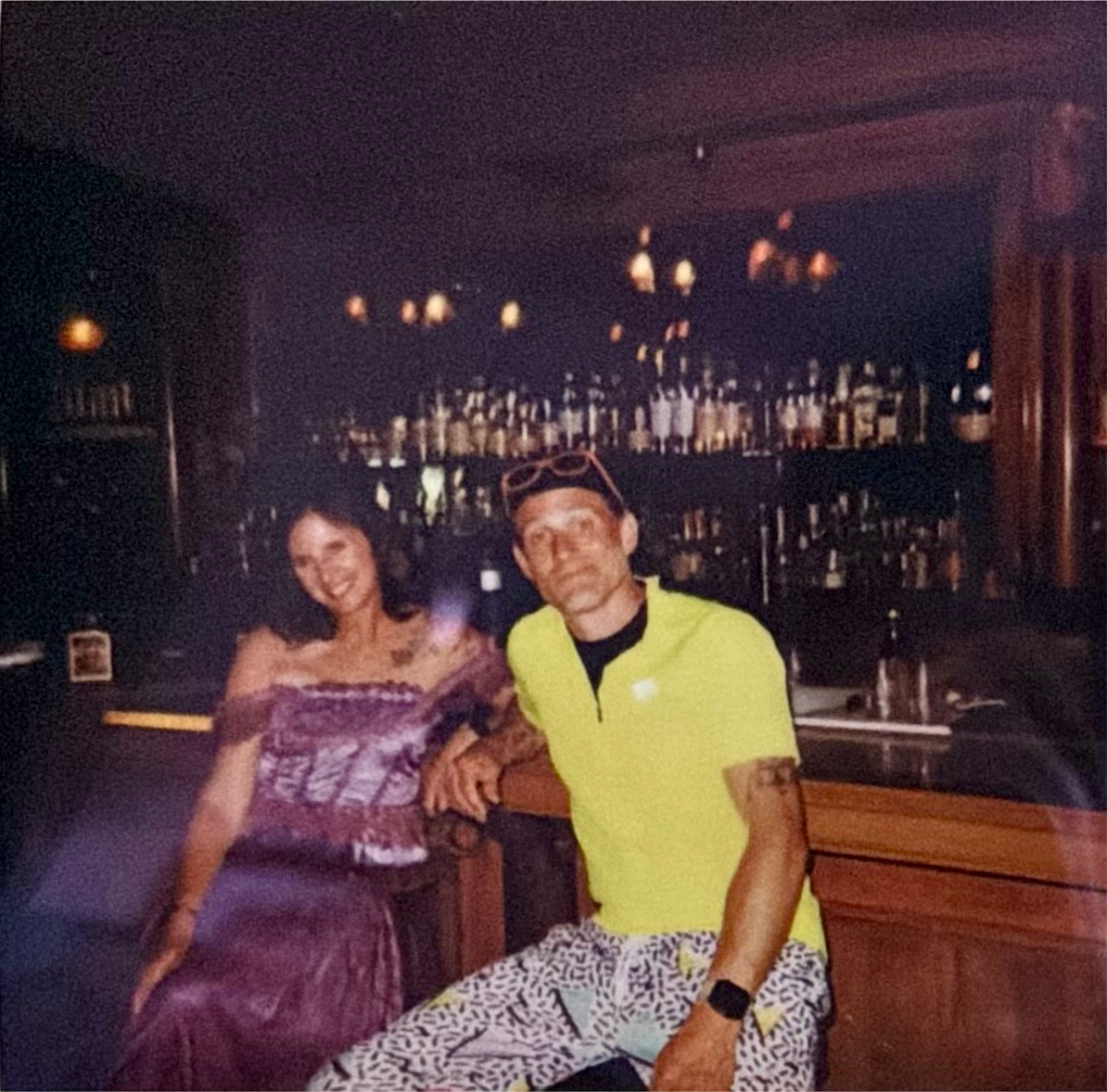 Rachel in purple and Jarod in bright yellow together at a bar